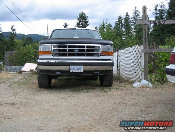 Front view of a black Ford F-Series truck with a chrome grille and a license plate reading 044-NHL