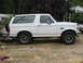 1995 Ford Bronco - Side profile of a white 1995 Ford Bronco with aftermarket wheels and tires.