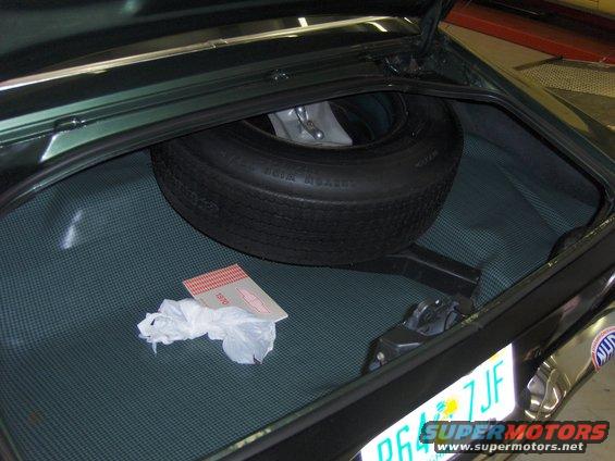 Trunk of a car with a spare tire, jack, and a 1970 owner's manual