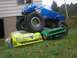 1994 Ford Escort - A blue toy monster truck is piled on top of two toy car bodies in a grassy yard.