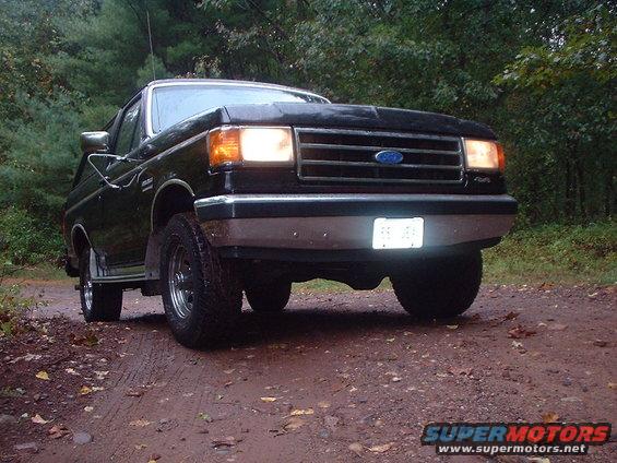 Black 1989 Ford Bronco front view on a dirt road