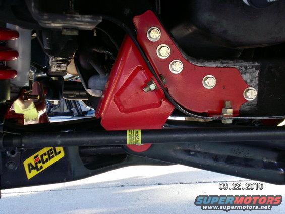 Close-up of red lift kit parts and Accel sticker on vehicle suspension