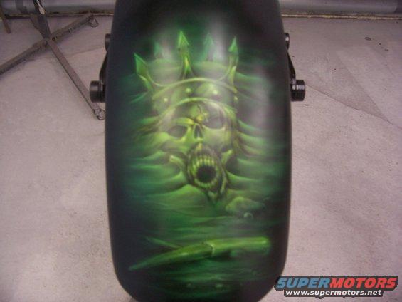 Motorcycle fender with airbrushed green skull wearing a crown and holding a knife