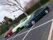 1971 Ford Mustang - Three cars are parked in a lot, including a red hatchback, a green sedan, and a dark green coupe.