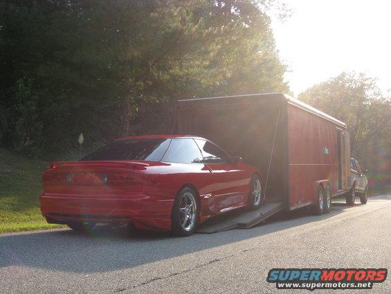 Red 1994 Ford Probe being loaded into a trailer