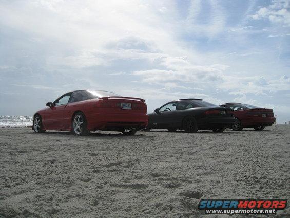 Red 1994 Ford Probe rear view on beach