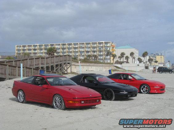 Red 1994 Ford Probe in 3/4 front view on a beach