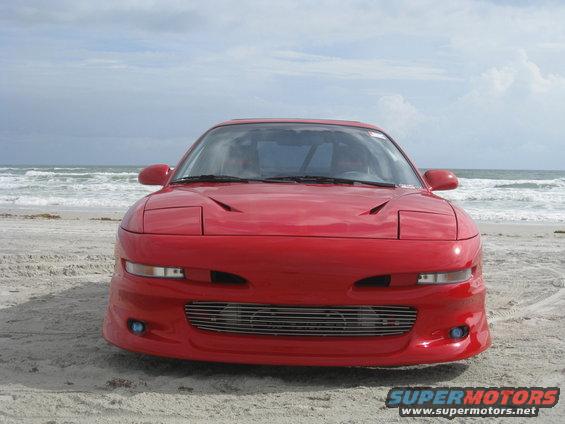 Red 1994 Ford Probe front view on a beach