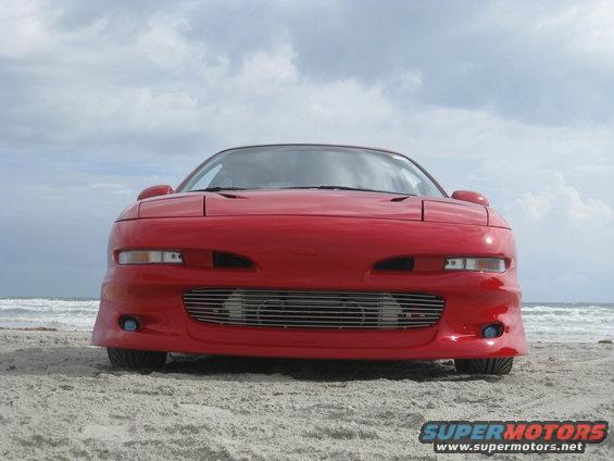 1994 Ford Probe front view on a sandy beach with ocean in background