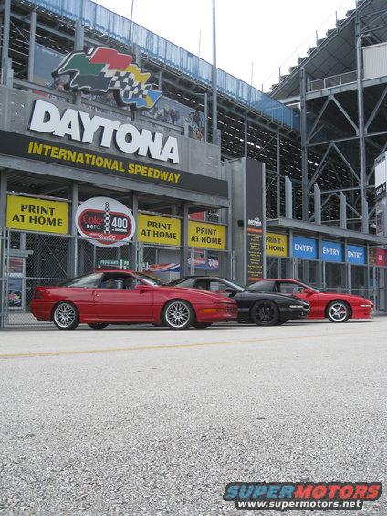 Red Ford Probe with aftermarket wheels parked at Daytona International Speedway