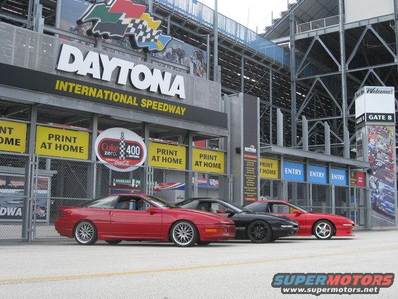 Three sports cars parked at Daytona International Speedway