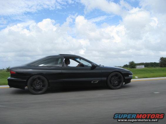 black 1994 Ford Probe GT driving on a road