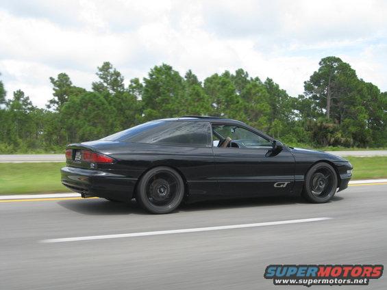 Black 1994 Ford Probe GT side view driving on highway