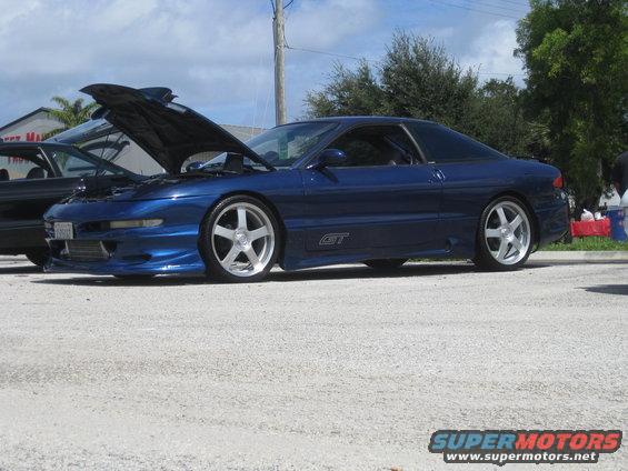 Blue 1994 Ford Probe GT with hood open, parked next to another car