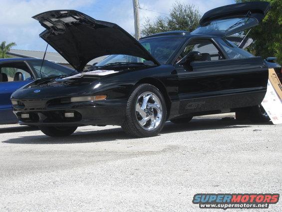 Black 1994 Ford Probe GT with hood and rear hatch open, chrome wheels, parked on asphalt