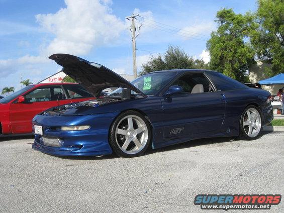 blue Ford Probe GT with hood open, parked next to a red car