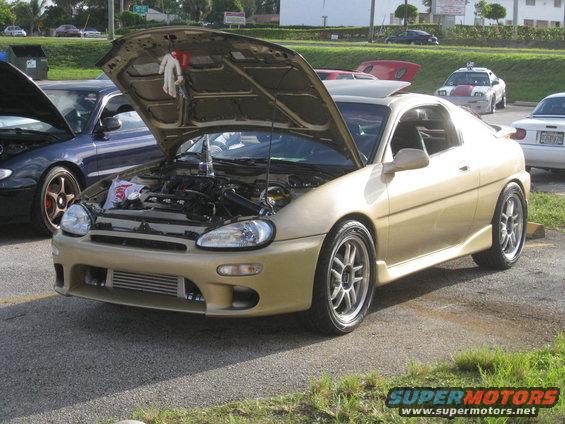 Gold coupe with hood open, aftermarket intercooler visible