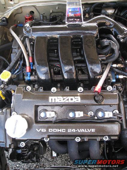 Close-up of a Mazda V6 DOHC 24-valve engine with custom intake manifold and braided fuel lines