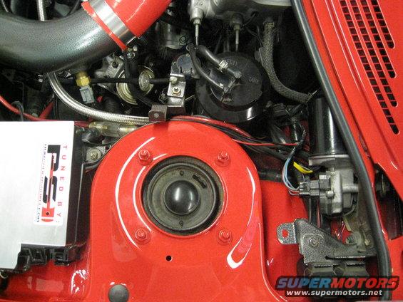 Close-up of engine bay with red paint, hoses, and a silver box labeled 'TUNED BY RSS'