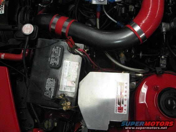 Engine bay with Interstate battery, red silicone intake hose, and a silver cover labeled "TUNED BY: RPF1.COM"