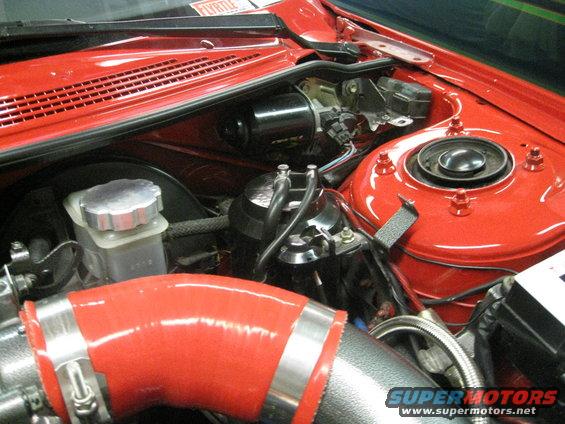 Engine bay with red intake hose and silver brake fluid reservoir
