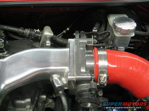 Close-up of engine intake manifold and throttle body with red silicone hose