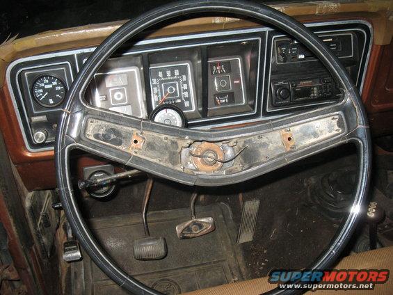 1977 Ford F-250 interior showing dashboard gauges, steering wheel, and pedals