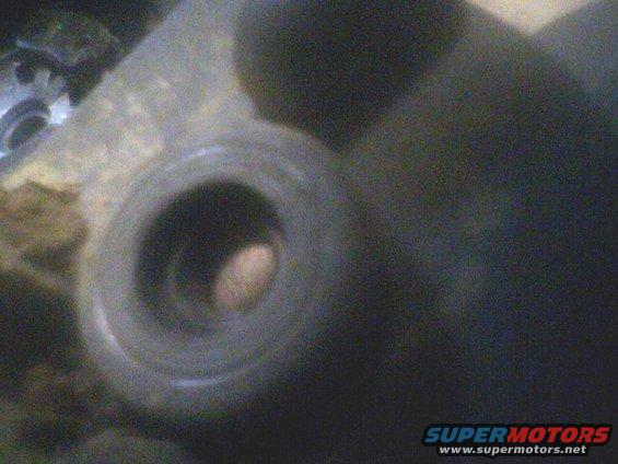 Close-up of a metal part with a hole and a gear visible