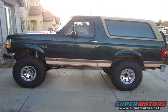 Green Ford Bronco with tan top, lifted with big tires