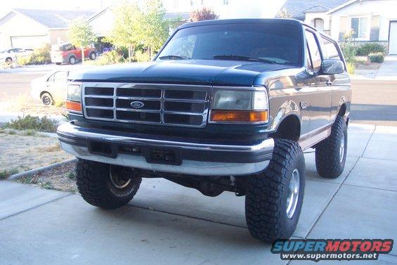 Dark blue Ford Bronco with lifted suspension and large tires, front 3/4 view