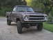 1980 Dodge Magnum - This lifted pickup truck features oversized tires and a rough, unfinished body, suggesting it's a project vehicle.