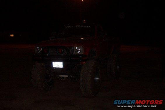 Red lifted truck with off-road banner and custom grille