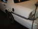 2003 Ford Crown Victoria - Bodywork in progress on a white sedan, showing primer and sanding marks on the rear fender.
