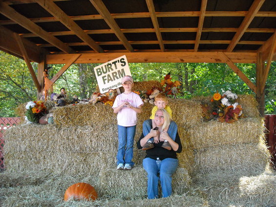 Family poses in front of hay bales at Burt's Farm in Dawsonville. A pumpkin is on the ground