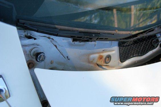 Cowl area of a car with visible rust and a wiper assembly