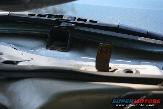 Close-up of windshield wiper pivot mount and mechanism on a car's cowl