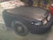2003 Ford Crown Victoria - A 2003 Ford Crown Victoria is shown in a workshop, with its front end covered in newspaper and primer, ready for a new paint job.