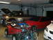 1979 Ford F-150 - Multiple vehicles and an ATV are parked inside a garage, with the truck's hood open.