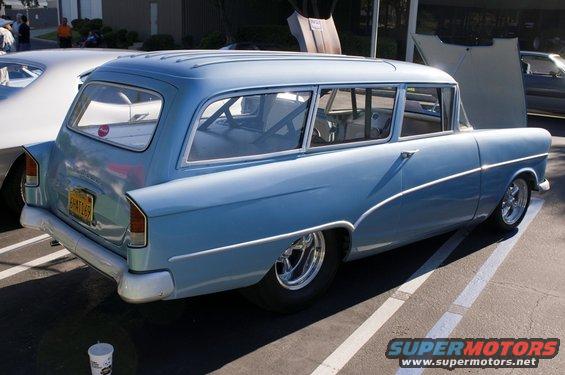 Blue station wagon rear view with roll cage and custom wheels