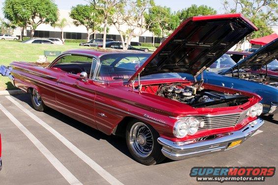 Red 1959 Pontiac Bonneville with hood open, parked in a lot