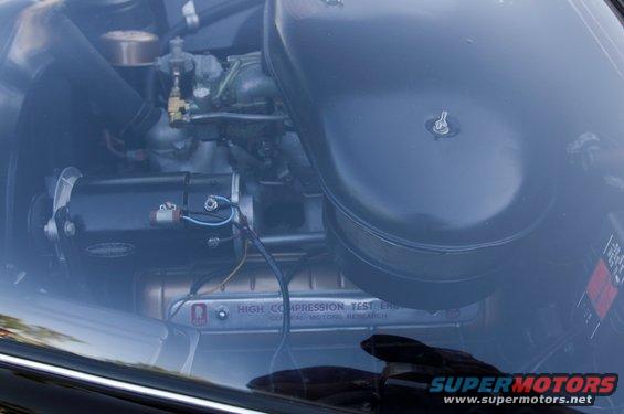 Engine bay with air cleaner, generator, and "HIGH COMPRESSION TEST ERS" label