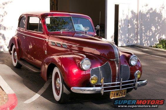 Red vintage sedan with whitewall tires and chrome grille