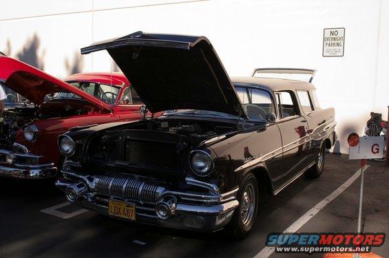 1955 Pontiac wagon, hood open, parked next to red car. Yellow license plate reads LDX 487