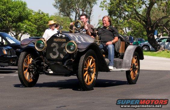 Hudson race car with number 33 on grille, two men and a straw-hatted man visible