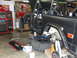 1967 Ford Mustang - A 1966 Ford Bronco is shown in a workshop, lifted on jack stands with its doors removed.