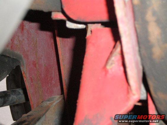 Close-up of red painted metal with rust and a black pipe
