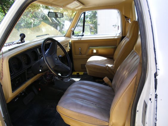 Tan vinyl seats and dashboard of a vintage truck interior, viewed from the passenger side