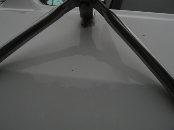 chrome roll bar mounted on white vehicle hood