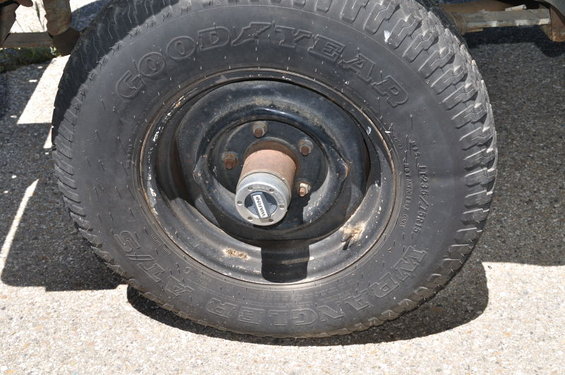 Close-up of a Goodyear Wrangler AT/S tire on a black rim with a Warn locking hub