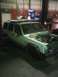 1993 Suzuki Sidekick - A Jeep Cherokee XJ is parked in a garage with its hood open, showing the engine bay.